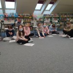 Powiększ zdjęcie Dzieci siedzą na podłodze w bibliotece 