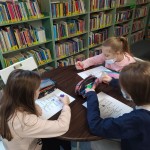 Powiększ zdjęcie Dzieci przy stolikach w bibliotece rozwiązują test o Karolci