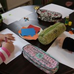 Powiększ zdjęcie Na zdjęciu ręce dzieci i materiały plastyczne na stoliku