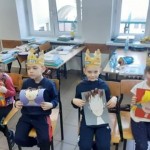 Powiększ zdjęcie na zdjęciu uczniowie w klasie siedzą na krzesłach w rękach trzymają prace plastyczne