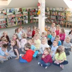 Powiększ zdjęcie Na zdjęciu w bibliotece dzieci siedzą na podłodze