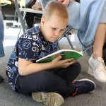 Powiększ zdjęcie Na zdjęciu chłopiec czyta książkę
