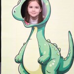 Powiększ zdjęcie Dziewczynka w fotobudce zielonego dinozaura