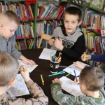Powiększ zdjęcie Dzieci siedzą przy stolikach i rozwiązują labirynt