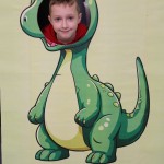Powiększ zdjęcie Chłopiec w fotobudce zielonego dinozaura