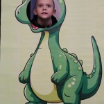 Powiększ zdjęcie Chłopiec w fotobudce zielonego dinozaura