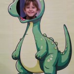 Powiększ zdjęcie Dziewczynka w fotobudce zielonego dinozaura