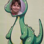 Powiększ zdjęcie Dziewczynka w fotobudce zielonego dinozaura