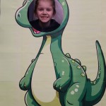 Powiększ zdjęcie Chłopiec w fotobudce zielonego dinozaura